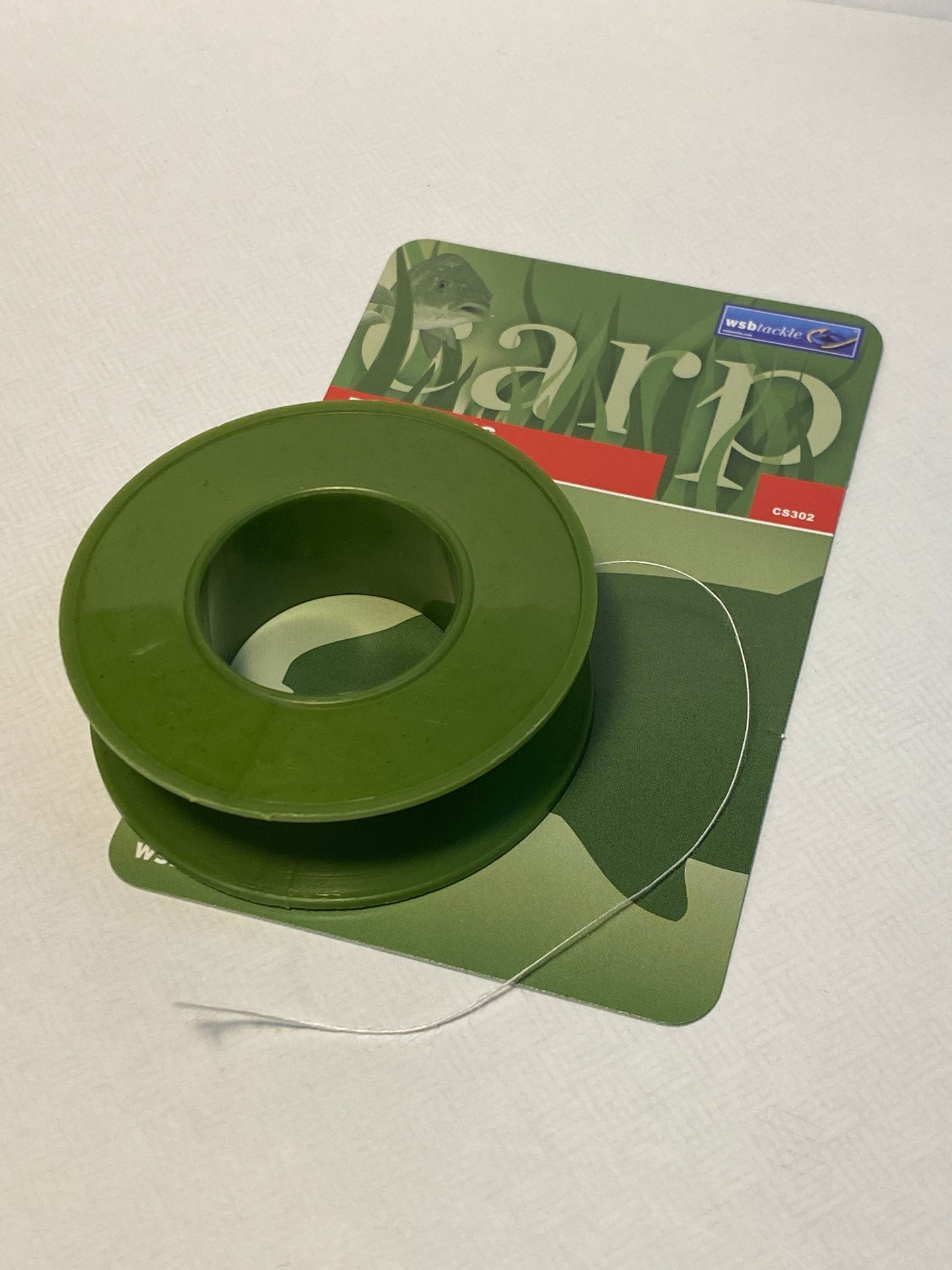 Green spool of PVA string on a white background