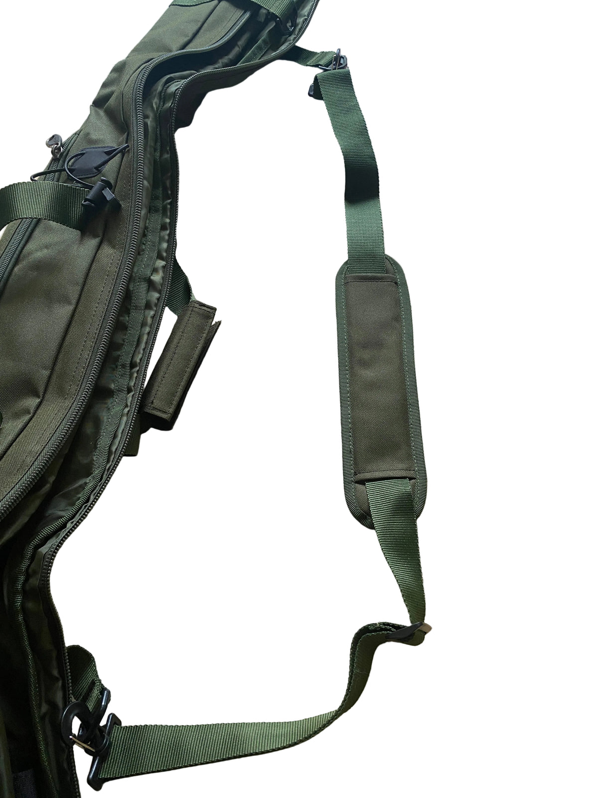 An olive green tactical sling bag with a padded shoulder strap, laid out on a light beige stone tile floor.