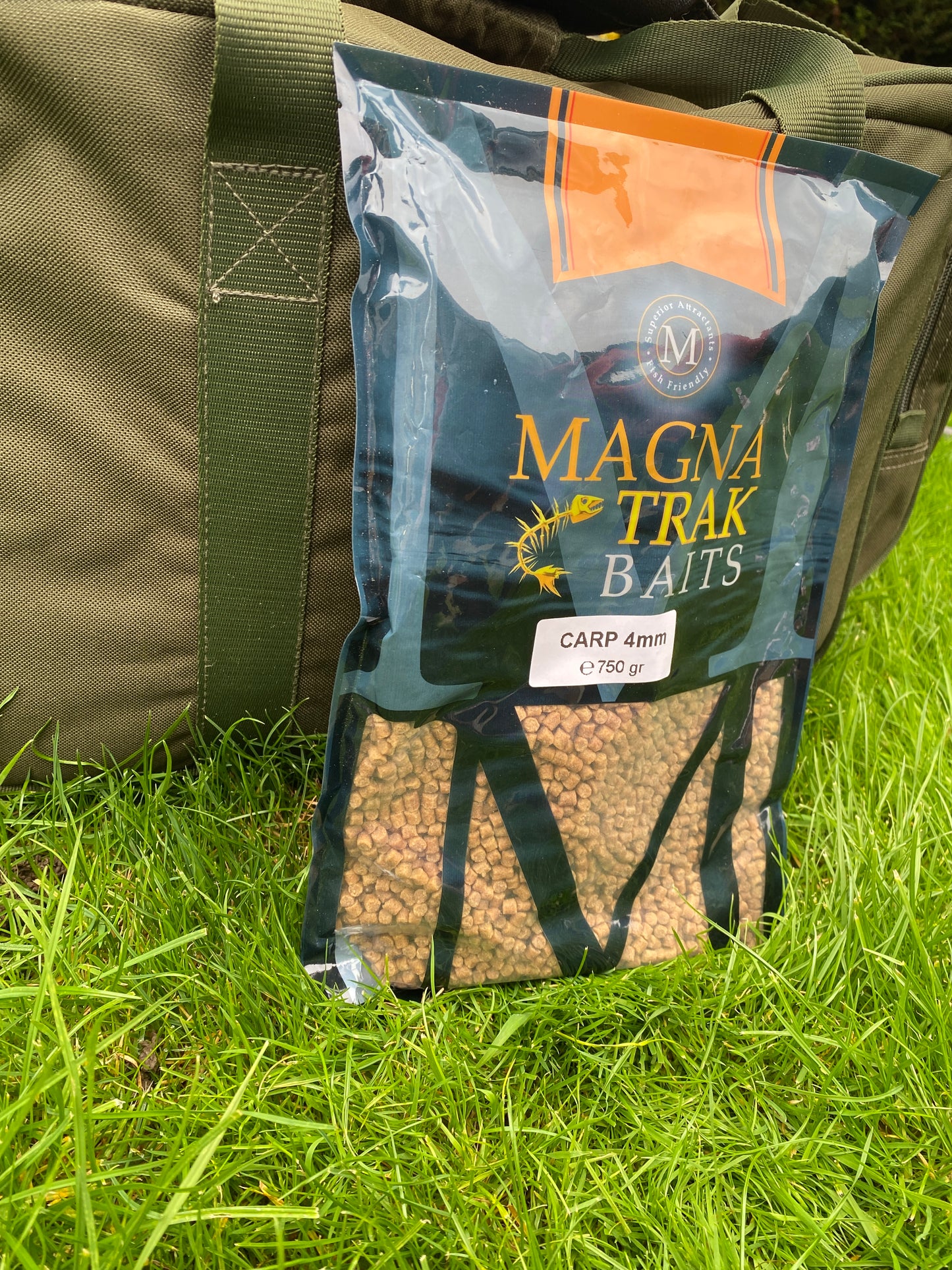 Magna Trak baits packaging on a green grass background