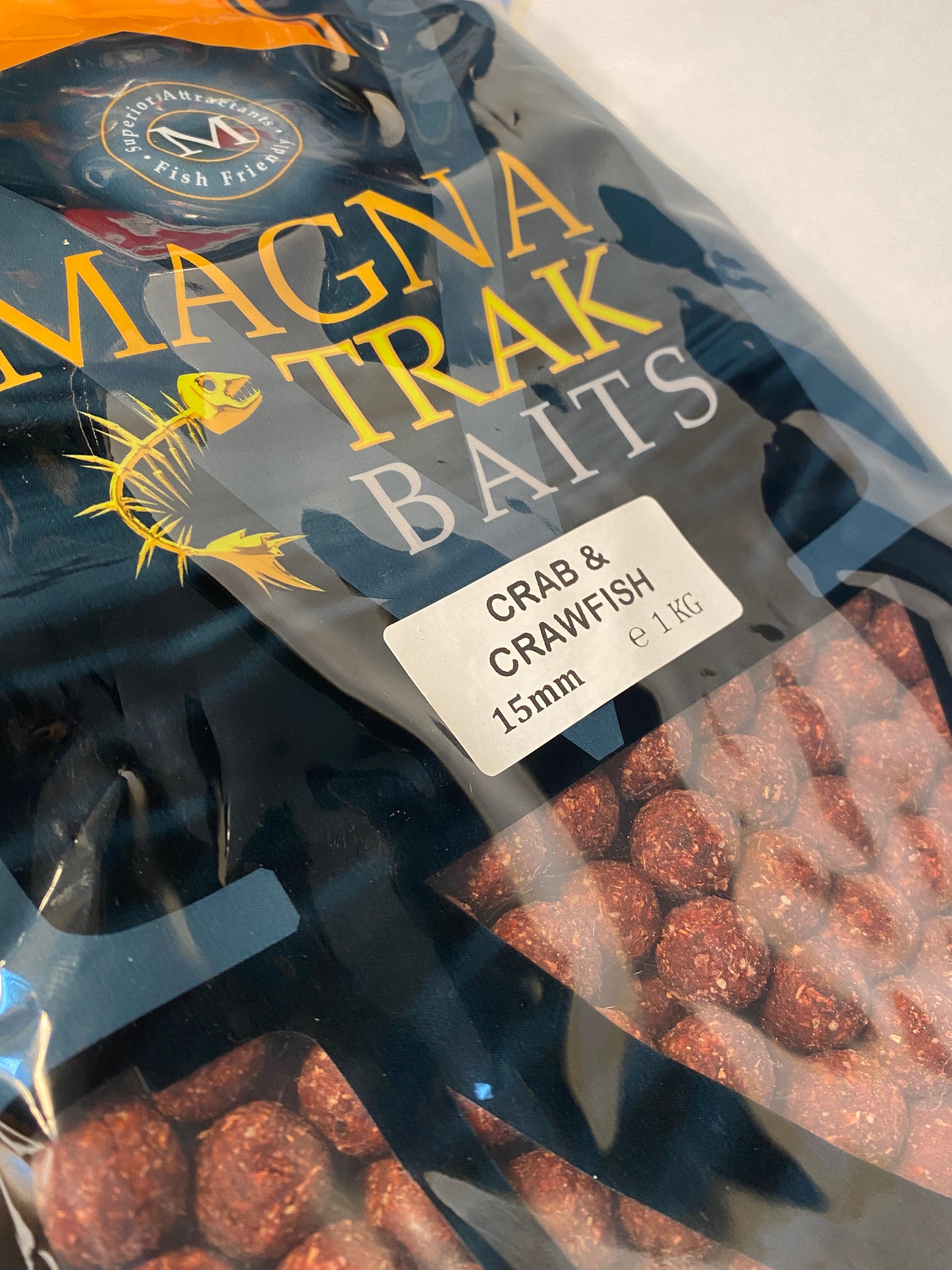 Packaged fishing baits with visible branding on a reflective surface