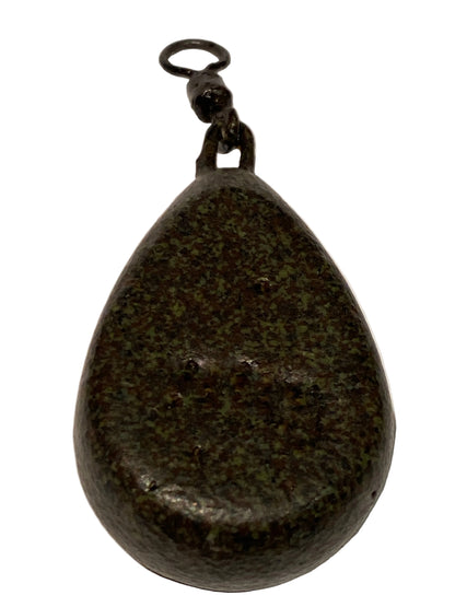 A dark, teardrop-shaped stone or polished rock with a small metal ring attached at one end, shown on a light textured background.