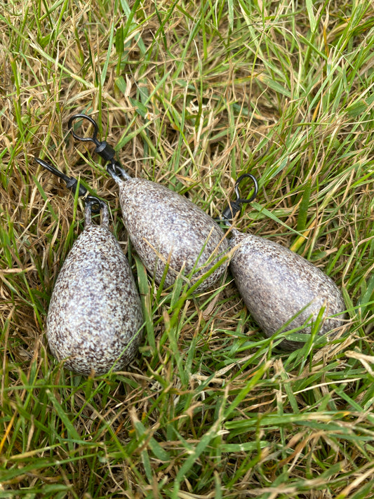 Three fishing weights on grass